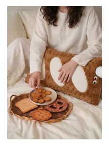 Détail d'un coussin en peluche en forme de baguette dans un décor de vie chaleureux