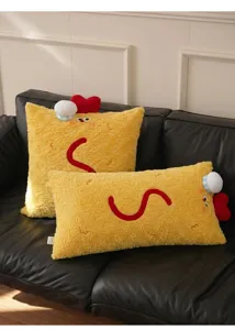 Vue rapprochée de deux coussins en peluche crevettes jaunes sur un canapé en cuir noir