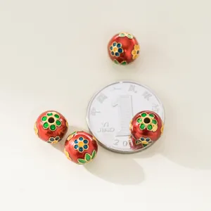 Detail van rode emaille bloemen S925 zilveren kralen naast een munt voor schaalvergroting