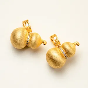 Close-up of brushed gold-plated Wu Lou pendants featuring sparkling micro-pave zirconia