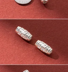 Close-up of 8mm 999 fine silver retro Dzi spacer beads with intricate textured patterns