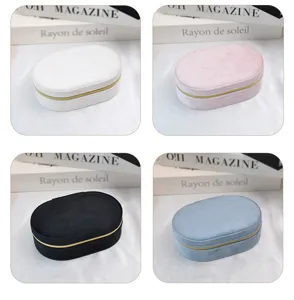 Detail view of four colors of portable oval velvet jewelry boxes for travel earring storage