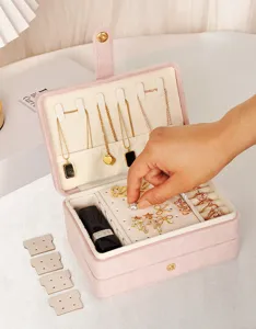 Détail d'une boîte à bijoux en velours rose à double couche avec boucles d'oreilles et bagues
