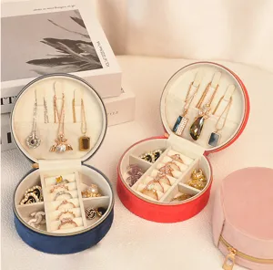 Detailed interior view of round velvet jewelry box showing ring slots and necklace hooks