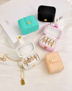 Detailed view of portable ring boxes in various colors with velvet lining for jewelry storage.