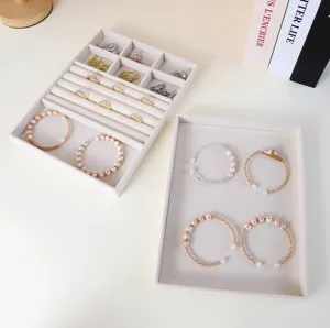Vista dettagliata di due vassoi portaoggetti in velluto beige per anelli e bracciali eleganti