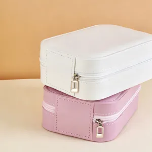Elegant portable travel jewelry box with zipper closure in white and pink faux leather finish