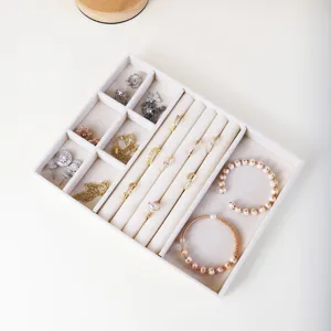 Elegante vassoio organizer per gioielli in velluto beige con scomparti per anelli.