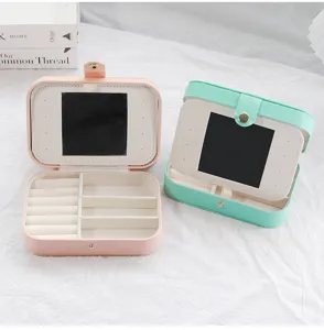 Open PU leather jewelry boxes in pink and green with mirrors and compartments.