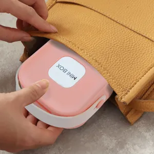 Portable pink mini jewelry storage box being placed inside a yellow stylish handbag