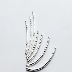 Macro detail of S925 silver curved tubes with textured diamond-cut pattern for DIY jewelry