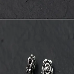 Close-up detail of S925 Thai silver rose flower spacer beads on textured background