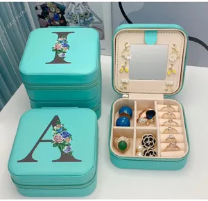Détail intérieur d'une boîte à bijoux en PU vert menthe avec miroir et initiale florale