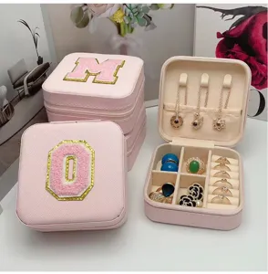 Detalle del joyero portátil rosa con iniciales bordadas y organizador interior de joyas.