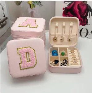 Detalle del joyero rosa bordado con compartimentos internos para almacenamiento.