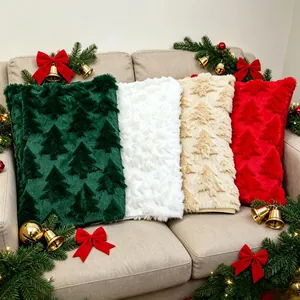 Close-up of four festive plush pillowcases with embossed Christmas tree patterns on a sofa.