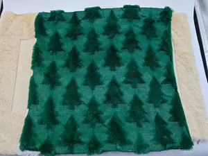 Macro view of green plush Christmas tree pattern on festive quilted velvet pillow cover