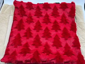Close-up of red plush Christmas pillowcase with quilted tree pattern texture.