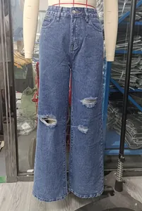 Detail view of light blue washed wide-leg jeans with ripped accents