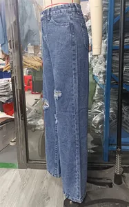 Detailed side view of light blue washed wide-leg ripped denim jeans on a mannequin