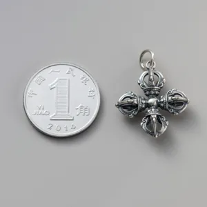 Detailed view of vintage 925 sterling silver Vajra pestle pendant next to a coin for scale