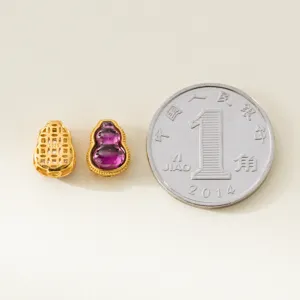 Makroaufnahme des Amethyst-Kürbis-Anhängers neben einer Münze zum Größenvergleich.