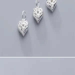 Gros plan de trois pendentifs cœur évidés en argent S925 pour la création de bijoux DIY