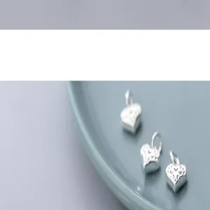 Vue macro détaillée de trois breloques cœurs évidés en argent sterling S925 pour bijoux DIY
