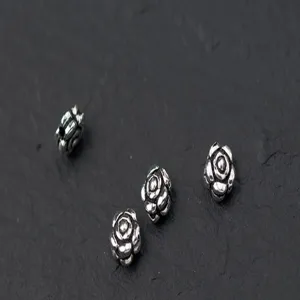 Detail view of four 925 silver rose-shaped spacer beads for DIY handmade jewelry making.
