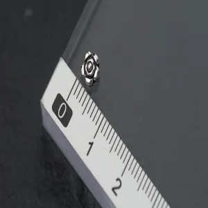 Close-up macro detail of S925 silver rose flower spacer bead with measurement scale
