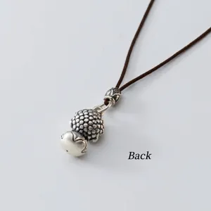 Detailansicht der Rückseite eines 999 Thai-Silber Lotus-Anhängers an brauner Schnur
