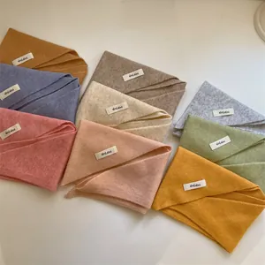 Detailed view of assorted wool blend knit triangle scarves in pastel and earth tones
