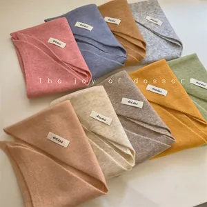 Close-up of soft wool-blend knit triangular scarves in various trendy pastel colors