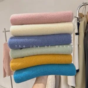 Detailed macro view of soft thick wool blend scarves stacked in various cozy autumn colors