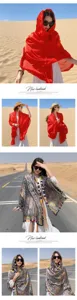 Asian model wearing a large red beach shawl and bohemian patterned scarf in a desert scene