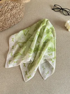Detailed texture of green cotton linen square scarf with elegant bow patterns