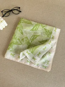 Detailed macro view of green cotton linen square scarf showing soft bow print textures