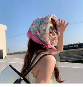 Close-up of floral cotton linen headscarf worn by a woman in bright outdoor setting