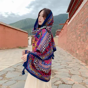 Detailansicht eines ethnischen Schals mit geometrischen Mustern und Quasten an einem asiatischen Model