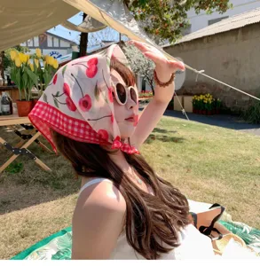 Girl wearing a cherry print cotton linen headscarf during a sunny outdoor picnic