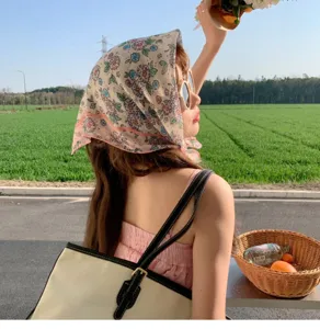 Outdoor lifestyle detail of a woman wearing a vintage floral cotton linen headscarf