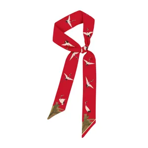 Dettaglio di sciarpa di seta stretta rossa con gru e padiglione cinese tradizionale.