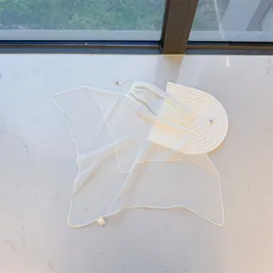 Detailed view of the white sheer sun protection face veil with adjustable ear loops.