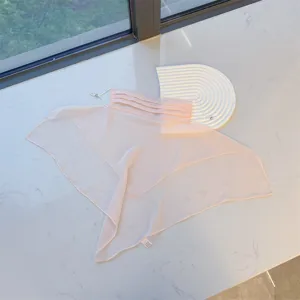 Detail view of light pink sun protection mask and neck veil in a clean lifestyle setting