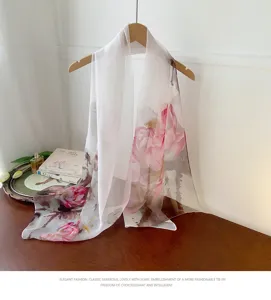 Detail view of a lightweight georgette scarf with elegant pink floral print on white.
