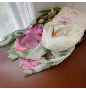 Detailed view of floral georgette scarf with elegant lotus print on wooden table
