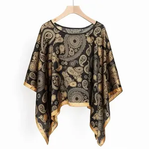 Elegantes Paisley- und Mandala-Print-Detail auf dem schwarzen, seidenähnlichen Strandponcho-Schal.