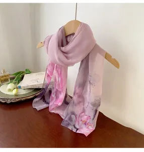 Detailed view of a purple floral georgette scarf hanging elegantly on a wooden hanger