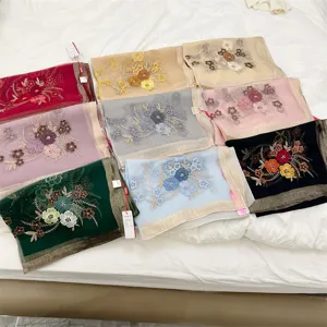 Various colorful silk blend scarves featuring elegant floral embroidery and gold borders.