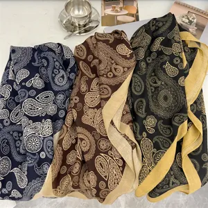 Detailed view of three paisley patterned cotton linen scarves in blue, brown, and black